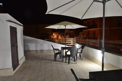 a table and chairs with umbrellas on a balcony at La casa di Bice in Cassibile