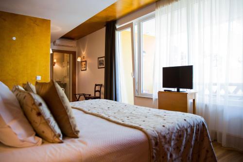 een slaapkamer met een bed, een raam en een televisie bij Cabecas do Reguengo in Portalegre