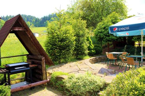 a garden with a grill and a table and chairs at pensjonat kuba in Korbielów