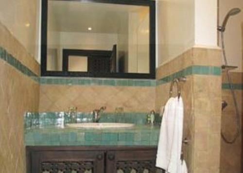 a bathroom with a sink and a mirror at Auberge Dar Najmat in Mirleft
