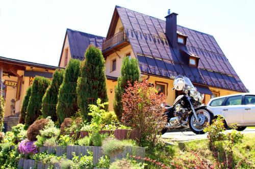 a motorcycle parked in front of a house at pensjonat kuba in Korbielów
