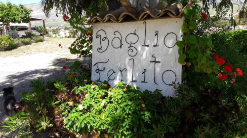 un cartel con escritura en un jardín en Baglio Ferlito, en Buseto Palizzolo
