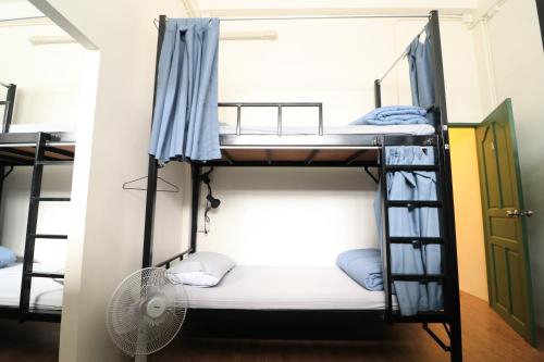 een slaapzaal met stapelbedden en een ventilator bij Krit Hostel in Bangkok