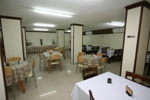 a dining room with tables and chairs and a room with tables and chairs at Cedar Hotel in Aqaba