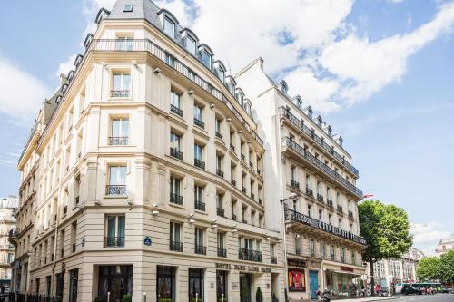 - un grand bâtiment blanc dans une rue de la ville dans l'établissement Hotel Park Lane Paris, à Paris