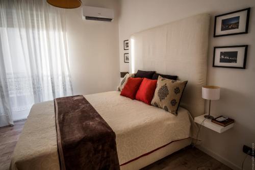 シラクーサにあるDomus Claudia - Casa Vacanzeのベッドルーム1室(赤い枕付きのベッド1台付)