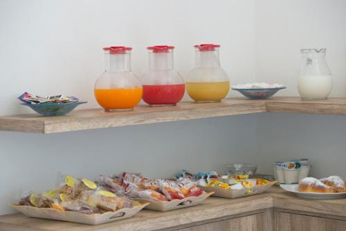 a shelf with four bottles of juice and bowls of food at B&B Casanova in Agerola