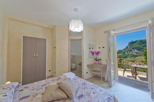 a bedroom with a bed and a balcony with a view at B&B Casanova in Agerola