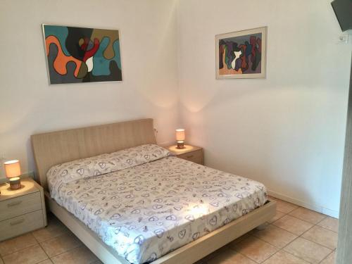 a bedroom with a bed and two night stands at Gardasol Holiday Apartment in Arco