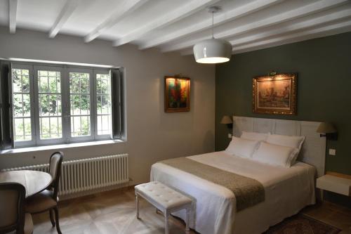 1 dormitorio con 1 cama, mesa y sillas en Campagne Paumier en Ansouis