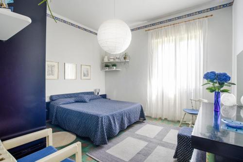 um quarto com uma cama e um vaso com flores azuis em Casa Clò em Trecastagni