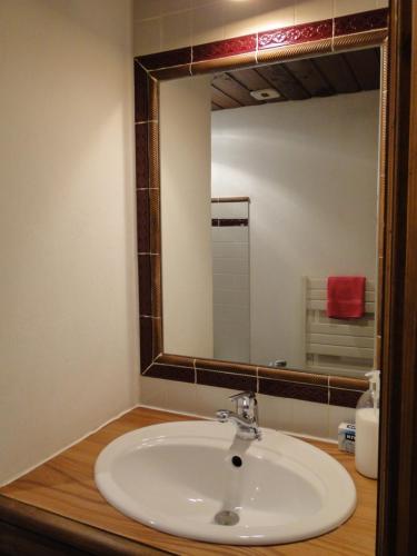 a bathroom with a sink and a large mirror at studio 103.Coeur de val in Val-d'Isère