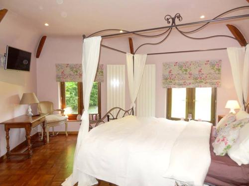 1 dormitorio con 1 cama blanca con dosel en Le chateau des eglantines en Montignies-le-Tilleul