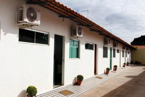 a white building with potted plants in front of it at Hotel New in Formosa