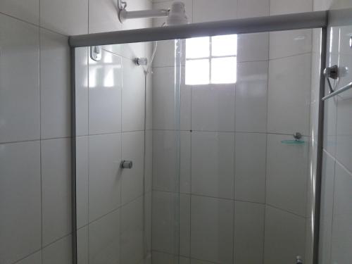 a shower with a glass door in a bathroom at Chale do Guidon in Imbassai