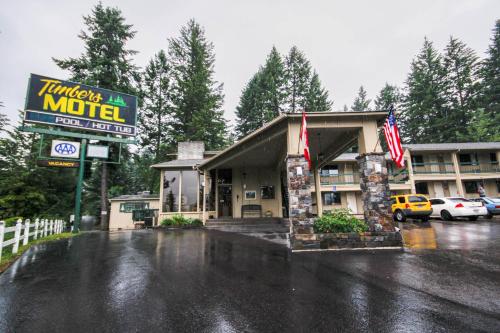 a hotel in a parking lot in the rain at Timbers Motel in Bigfork