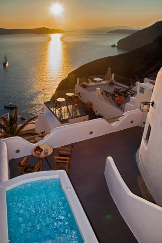 a view of a resort with a swimming pool and the ocean at Aperto Suites - Adults Only in Fira