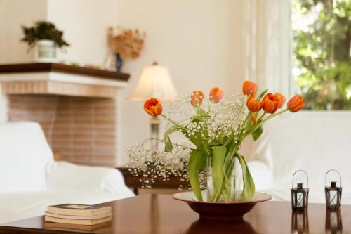 a vase of orange and white flowers on a table at Porto Heli Villa in Porto Heli
