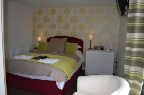 a bedroom with a bed with green pillows at Red Lion Inn in Newbrough