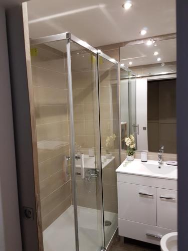 a bathroom with a glass shower and a sink at Hello Sun in Vilamoura