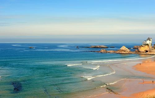 a view of a beach with people in the water at Hôtel Kemaris in Biarritz