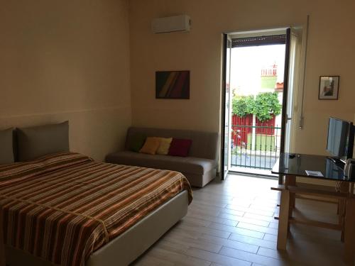 サンタ・テレーザ・ディ・リーヴァにあるCasa Vacanze da Cettinaのベッドルーム(ベッド1台、ソファ、テレビ付)