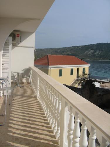 d'un balcon avec un escalier menant à une maison jaune. dans l'établissement Apartment Nizic, à Primošten