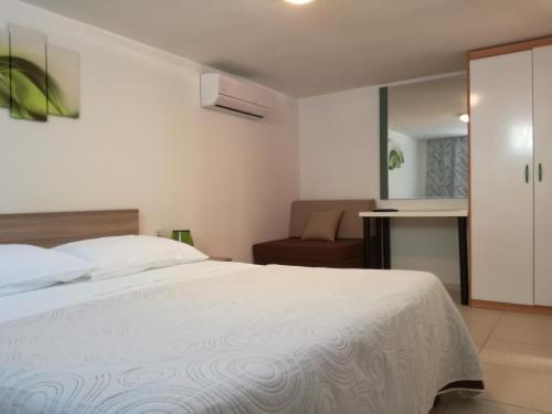 - une chambre avec un lit blanc et une chaise dans l'établissement Apartman Anni, à Poreč