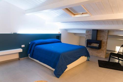 AcriにあるB&B Sandro Pertiniのベッドルーム(青いベッド1台、暖炉付)