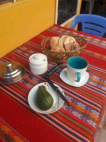 a table with a plate of bread and a bowl of avocado at Hostel Climbing Point in Huaraz