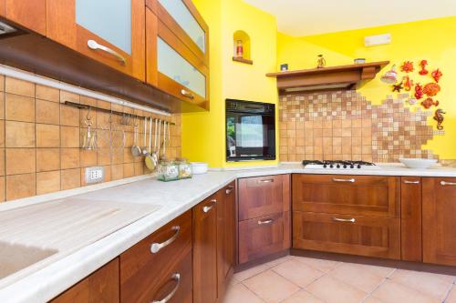マッサ・ルブレンセにあるBella Brianaの黄色の壁の広いキッチン(木製キャビネット付)