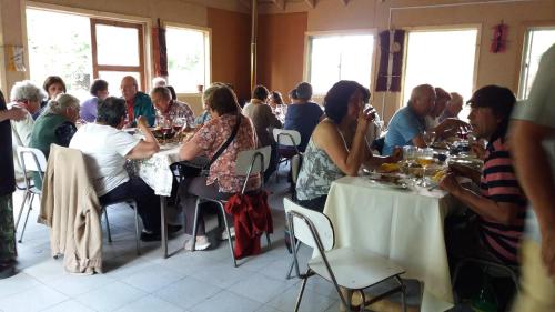 a group of people sitting at tables in a room at Cabañas Aguas Claras in Pinto