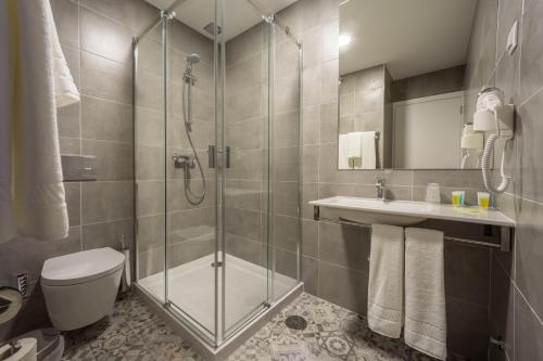 a bathroom with a shower and a toilet and a sink at Micasa Inn Fátima in Fátima