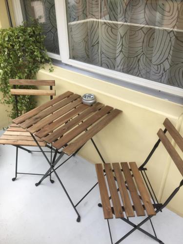 a bench and two chairs in front of a window at Stay Switzerland Apartments in Interlaken