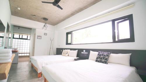 two beds in a room with two windows at The Red Hotel in Nanwan