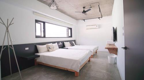a bedroom with two beds and a window at The Red Hotel in Nanwan