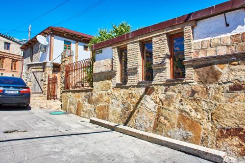 a car parked in front of a stone building at Guest House Savane in Gori