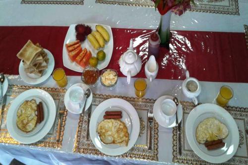 uma mesa com pratos de café da manhã sobre ela em Himawari Hills em Nuwara Eliya