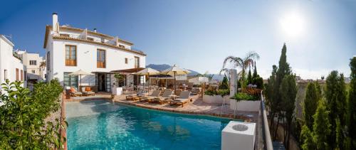 a swimming pool in front of a building with chairs at Hotel Boutique La Serena - Altea in Altea