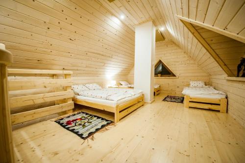una camera con due letti in una cabina di legno di Osada Stary Bór a Murzasichle