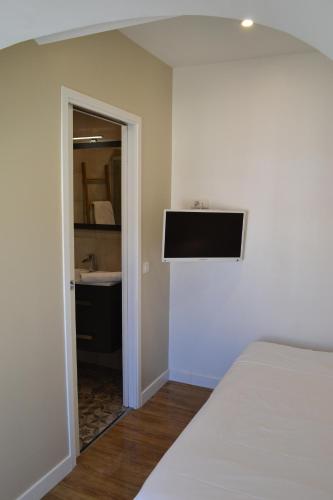 une chambre avec un lit et une télévision au mur dans l'établissement 2 pièces Vagliano, à Cannes