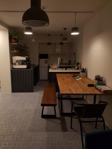 a kitchen with a wooden table and a dining room at Hostel Single Single in Busan