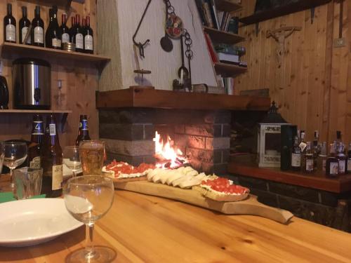 a table with two pizzas in front of a fireplace at Rifugio Guide Frachey in Saint Jacques