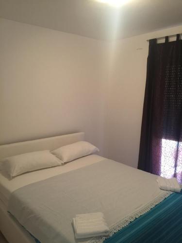 1 cama con 2 almohadas en una habitación con ventana en Sweet Home Zadar, en Zadar