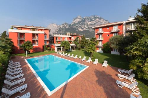 een resort met een zwembad en stoelen en gebouwen bij Brione Green Resort in Riva del Garda