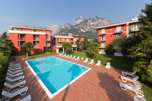 un complejo con piscina, sillas y edificios en Brione Green Resort, en Riva del Garda