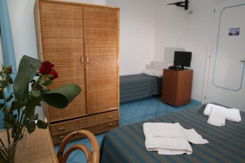 Habitación con cama y tocador con toallas en Affittacamere Via Muraglione, en Ventotene