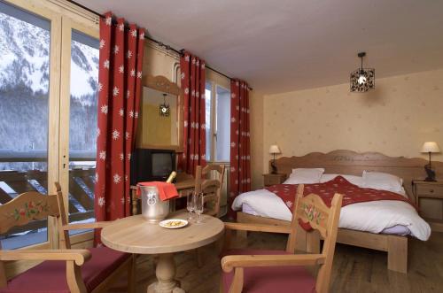 Villar-dʼArène的住宿－古幣酒店，卧室配有一张床和一张桌子及椅子