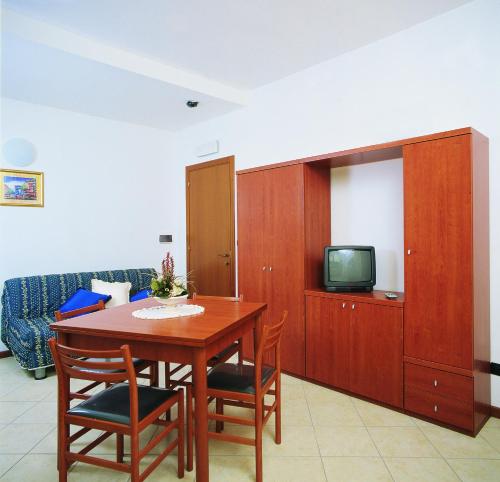 uma sala de estar com uma mesa de madeira e uma televisão em Residence Vittoria em Alba Adriatica