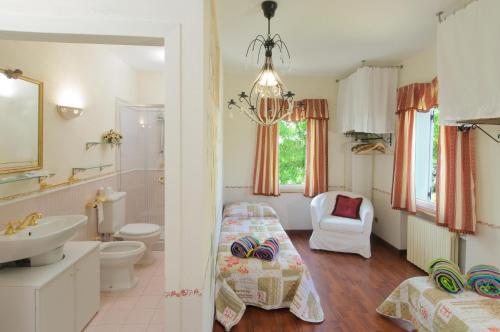 a bathroom with a bed and a toilet and a sink at B&B Villa Le Terrazze in Mondaino
